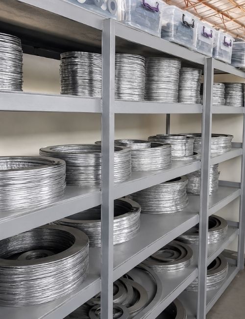 Rubber Bellows and Flanged Connectors Stock Warehouse stock area with wooden crates containing flanged connectors and industrial components for rubber bellows and piping applications.